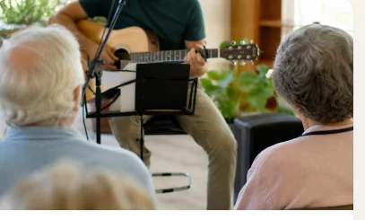 Idosos ouvindo música ao violão em musicoterapia